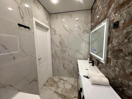 La salle de bains est pourvue d'un lavabo et d'un miroir. dans l'établissement Aportament in Abyroy Residence, à Atyraū