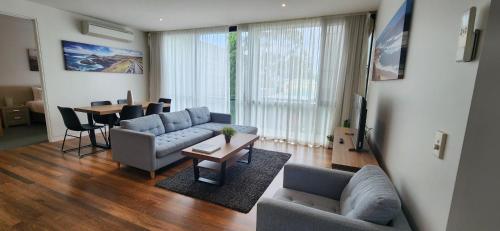 a living room with a couch and a table with chairs at Phillip Island Apartments in Cowes