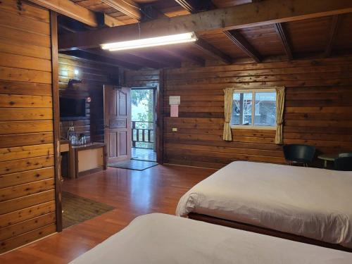 a bedroom with a bed and a kitchen in a cabin at Gemlu in Lugu