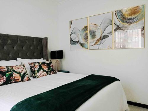 - une chambre dotée d'un lit avec une couette et des photos vertes dans l'établissement Lite Home, à Fourways