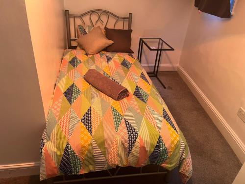 a bed with a colorful comforter in a room at SouthStreet Suites in Isleworth