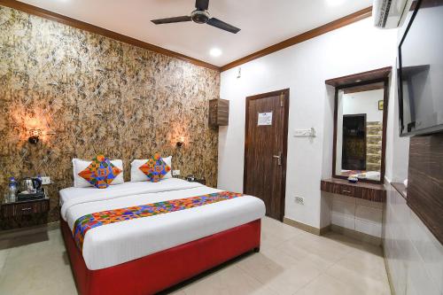 um quarto com uma cama e uma televisão de ecrã plano em FabExpress New Diamond em Calcutá