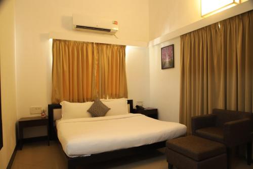 a hotel room with a bed and a chair at Casabela Boutique Hotel in Porvorim