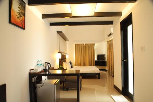 a bedroom with a bed and a desk in a room at Casabela Boutique Hotel in Porvorim