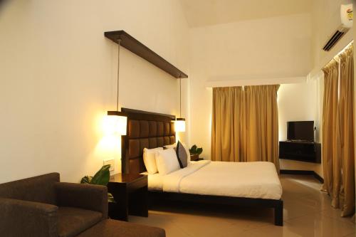 a hotel room with a bed and a couch at Casabela Boutique Hotel in Porvorim