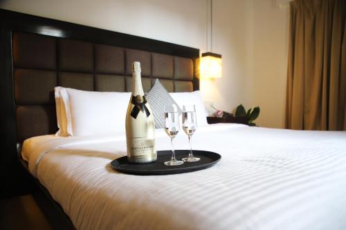 a bottle of champagne and two glasses on a bed at Casabela Boutique Hotel in Porvorim