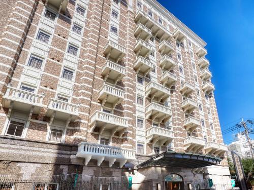 un gran edificio de ladrillo con balcones. en GRG Hotel Naha Higashimachi, en Naha