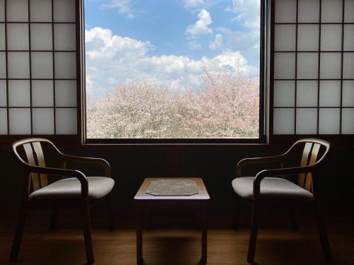 two chairs and a table in front of a window at 吉野荘湯川屋 Yoshinosou Yukawaya in Yoshino