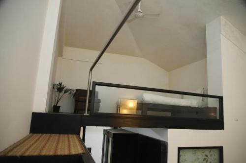 a loft bedroom with a bed and a mirror at Casabela Boutique Hotel in Porvorim
