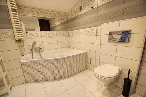 a bathroom with a tub and a toilet and a sink at FV/ Mariacka 7 - Studio apartment -Katowice in Katowice