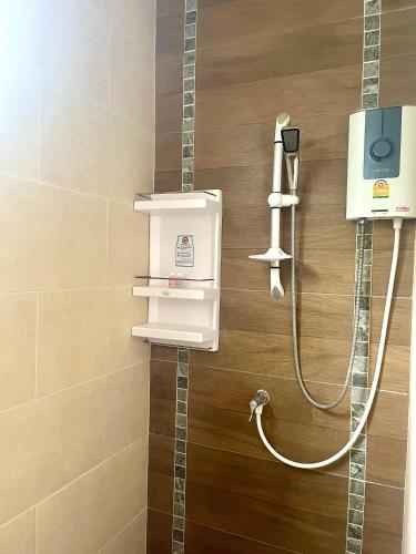a shower in a bathroom with a soap dispenser at Tan Residence in Ko Lanta