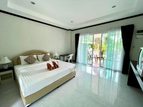 a bedroom with a bed with two shoes on it at Tan Residence in Ko Lanta