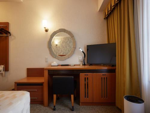 a room with a desk with a computer and a mirror at GRG Hotel Naha Higashimachi in Naha