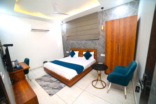 1 dormitorio con 1 cama y 1 silla azul en ROYAL PALACE, en Bhiwāni