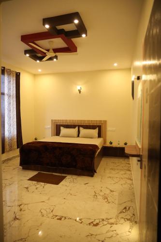 een slaapkamer met een bed en een plafond bij HOTEL AKSHAYAM GRAND INN in Yelagiri