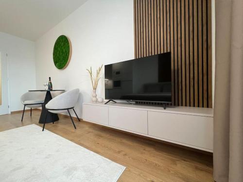 a living room with a large television on a white cabinet at Apartmán SoHo s private garage parking free, 5 min peso do centra in Košice