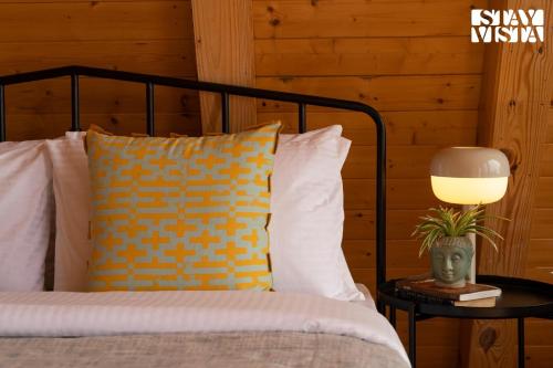 a bedroom with a bed with a lamp on a table at StayVista at The Goldilocks with Pvt Pool & Gym in Bengaluru