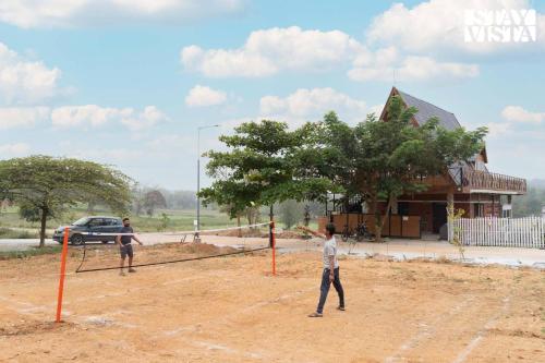two men playing a game of volleyball in front of a building at StayVista at The Goldilocks with Pvt Pool & Gym in Bengaluru