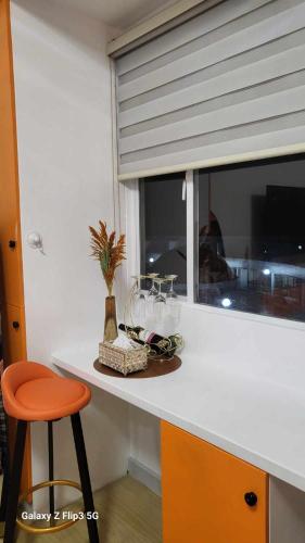 a kitchen counter with a stool and a window at MNK Condo Transient - Albergo Residences in Baguio
