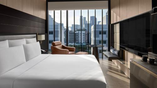 InterContinental Singapore Robertson Quay, an IHG Hotel في سنغافورة: غرفة فندقية بسرير ونافذة كبيرة