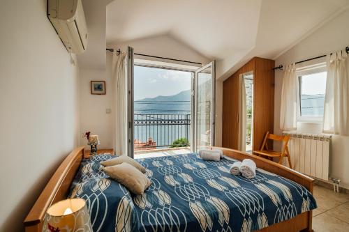 sypialnia z łóżkiem i dużym oknem w obiekcie Holiday Home Amanda Hollick w Kotorze
