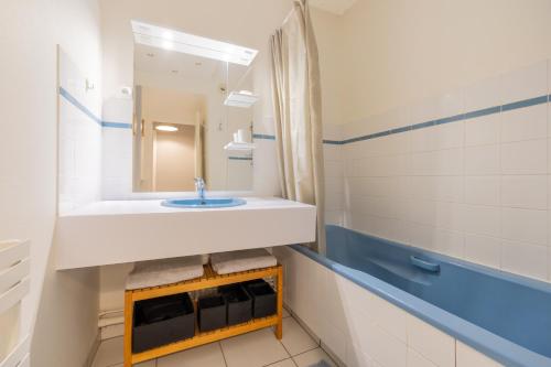 uma casa de banho com um lavatório e um espelho em Front de mer vue exceptionnelle em Granville