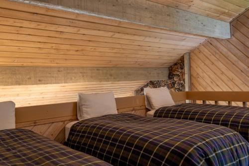 Habitación con 2 camas en una habitación con paredes de madera. en Sunburst Condo 2739 - Warmly Updated, Leather Furniture and Mountain Views en Elkhorn Village