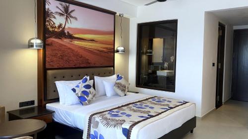 sypialnia z łóżkiem z obrazem na ścianie w obiekcie Emerald Bay Resort Mirissa w mieście Mirissa