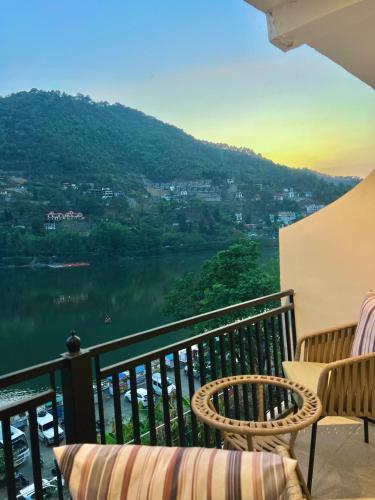 a balcony with two chairs and a view of a lake at The Lake Hill - Ridge in Bhīm Tāl