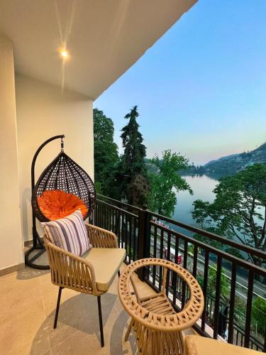 a porch with a swing and a chair on a balcony at The Lake Hill - Ridge in Bhīm Tāl