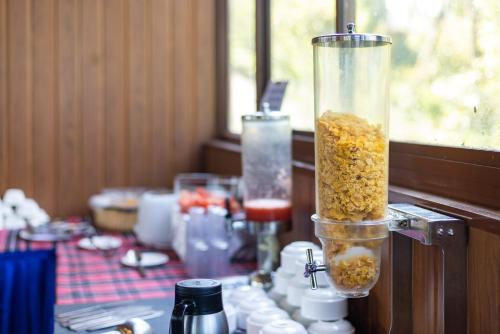a table topped with a container filled with food at Eterno Camellia & Elettaria Resort with Pool in Munnar