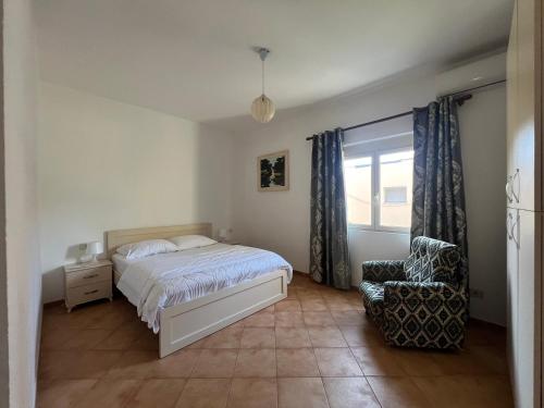 1 dormitorio con 1 cama, 1 silla y 1 ventana en Vivo Apartment en Durrës