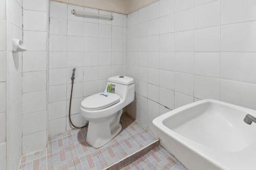 a white bathroom with a toilet and a bath tub at Phu Inn Hotel in Khon Kaen