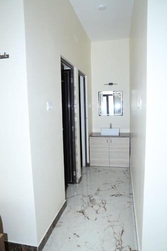 a white bathroom with a sink and a mirror at HOTEL AKSHAYAM GRAND INN in Yelagiri