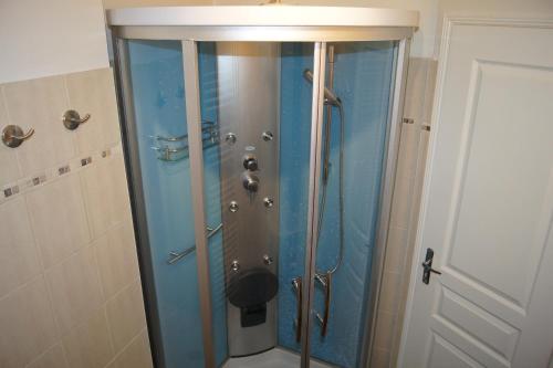 a shower with a glass door in a bathroom at La Citadine in Bayeux