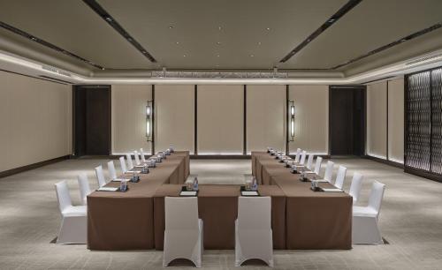a conference room with long tables and white chairs at InterContinental Shenzhen WECC by IHG in Shenzhen