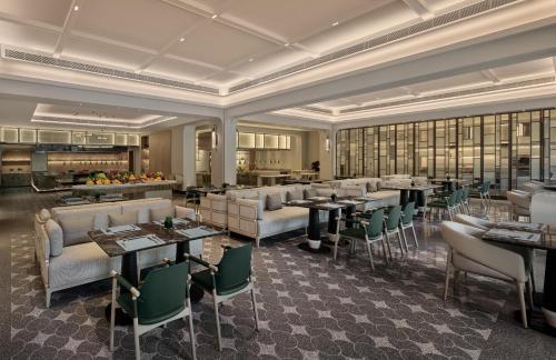 a restaurant with couches and tables in a room at InterContinental Shenzhen WECC by IHG in Shenzhen
