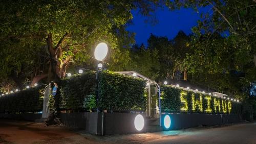 a hedge with lights on it at night at Swimup - Suites with private pool , Vagator in Vagator