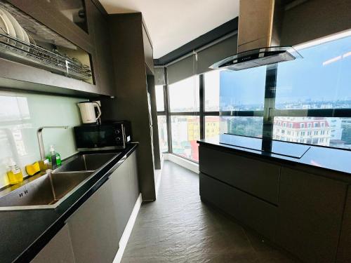 a kitchen with a sink and a counter with a window at Ficus Suites in Hanoi