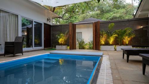 a swimming pool in a backyard with a house at Swimup - Suites with private pool , Vagator in Vagator