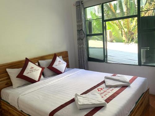 Vang Vieng Lily Backpackers Hostel في فانغ فينغ: غرفة نوم عليها سرير وفوط