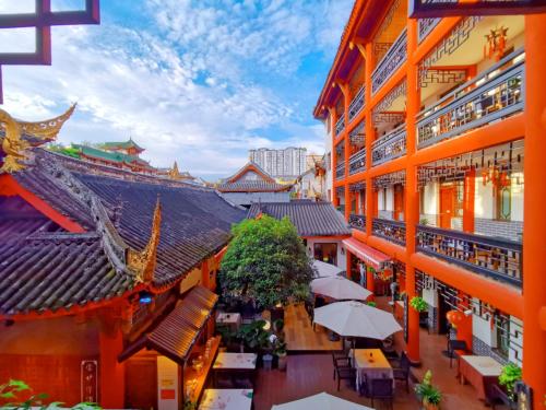 成都市にあるWenjun Courtyard Hotel Chengdu ( Kuanzhai Branch)のテーブルと傘が備わる建物の上面の景色
