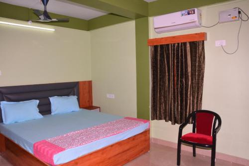 1 dormitorio con 1 cama y 1 silla roja en SEA SUN PARADISE, en Port Blair