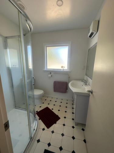 ein Bad mit einer Dusche, einem Waschbecken und einem WC in der Unterkunft Sunny House with 5 Bedrooms(near airport) in Christchurch
