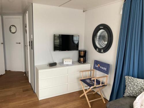a living room with a tv and a chair at Hausboot Jette in Werder