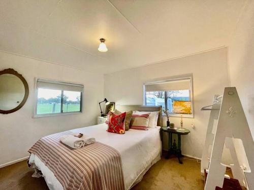 a bedroom with a bed and a window at The Vigneron's Cottage at Dragonfly Estate Vineyard - Stanthorpe in Severnlea