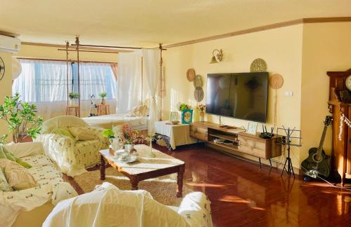 a living room with a couch and a tv at Secret garden in Chiang Mai