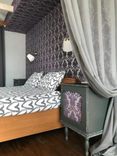 ein Schlafzimmer mit einem Bett und einem Vorhang in der Unterkunft Villa del Grossa Будинок з каміном та чаном на дровах in Kuchakiv