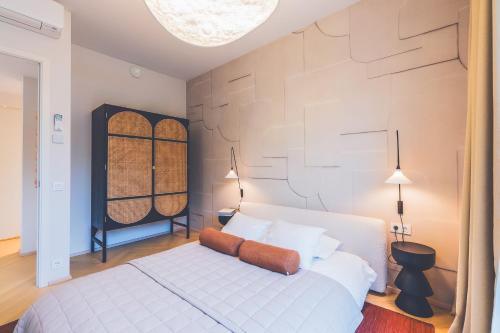 a bedroom with a white bed and a wall at Second Home Stay 17 in Pärnu