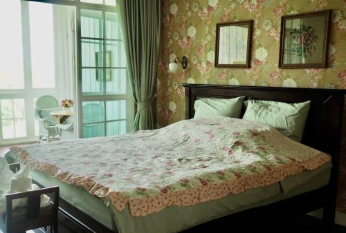 a bedroom with a large bed with a pink blanket at Hacienda Home in Tha Sut